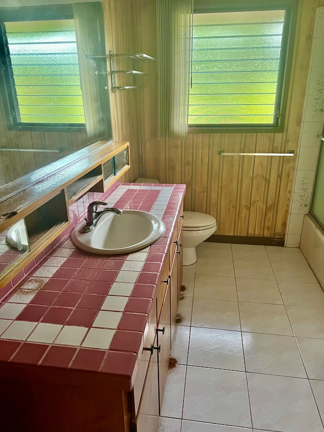 bathroom with wood walls, tile patterned flooring, vanity, and toilet