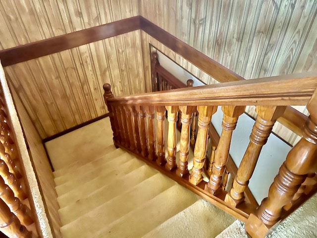 stairway featuring wood walls