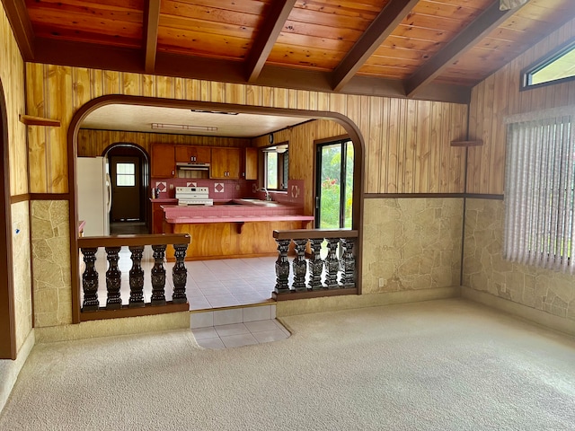 kitchen with wooden walls, beamed ceiling, white appliances, and wood ceiling