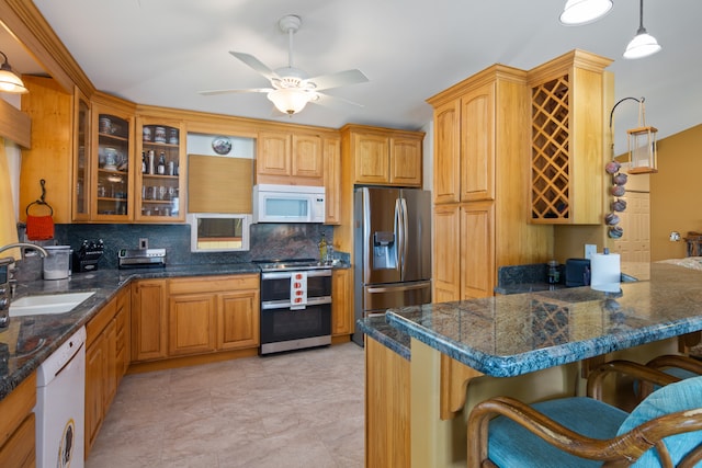 kitchen featuring ceiling fan, sink, hanging light fixtures, stainless steel appliances, and backsplash