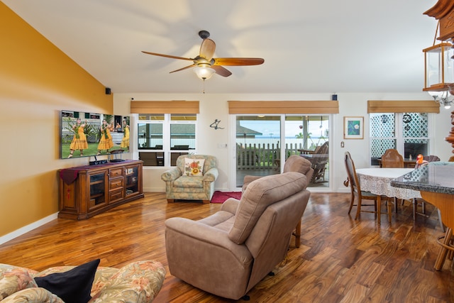 living room with hardwood / wood-style flooring, ceiling fan, and vaulted ceiling