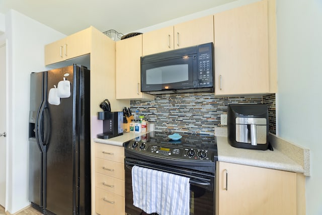 kitchen featuring black appliances, light brown cabinetry, and tasteful backsplash