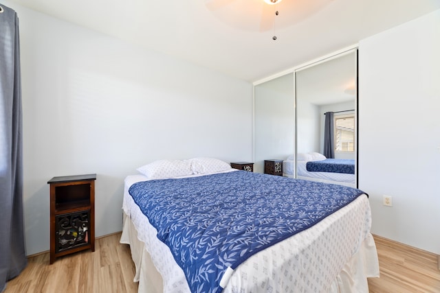 bedroom with wood-type flooring, ceiling fan, and a closet