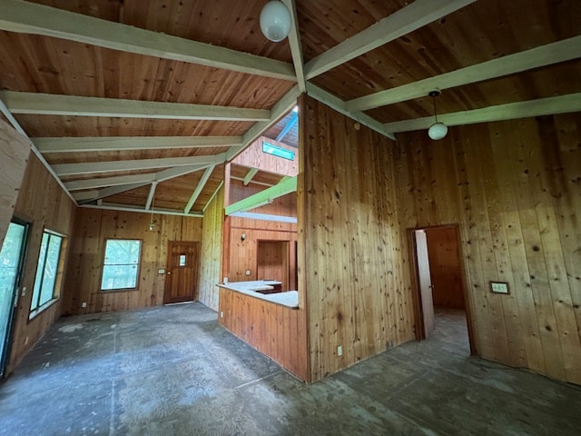 unfurnished living room with wood ceiling, lofted ceiling with beams, and wooden walls