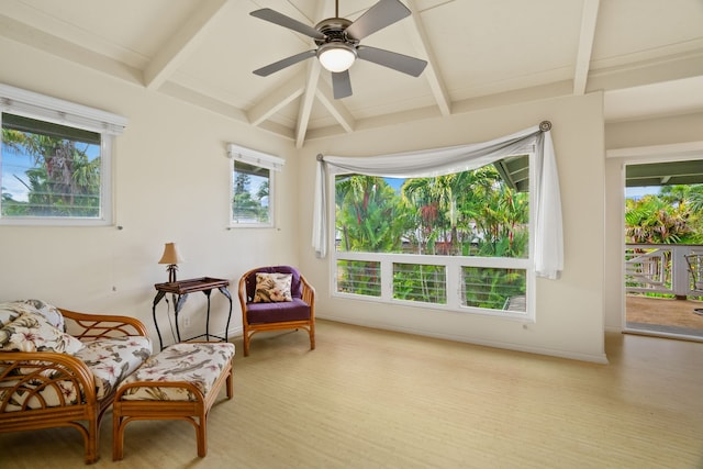 living area featuring a wealth of natural light, light hardwood / wood-style floors, ceiling fan, and vaulted ceiling with beams