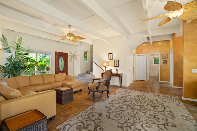 living room featuring ceiling fan, dark tile patterned floors, and vaulted ceiling with beams