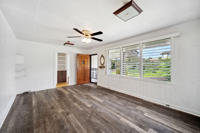 unfurnished bedroom with ceiling fan and dark wood-type flooring