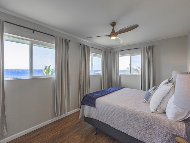 bedroom with ceiling fan, a water view, and dark hardwood / wood-style floors