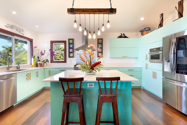 kitchen with appliances with stainless steel finishes, island range hood, a kitchen island, and sink