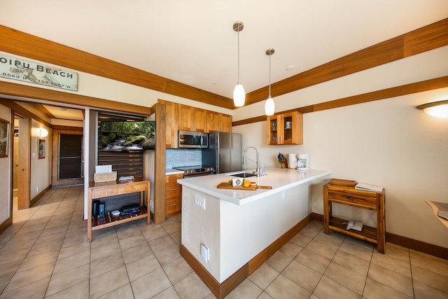 kitchen with hanging light fixtures, sink, decorative backsplash, appliances with stainless steel finishes, and kitchen peninsula