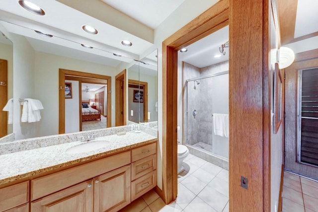 bathroom featuring tile patterned flooring, vanity, toilet, and a shower with shower door