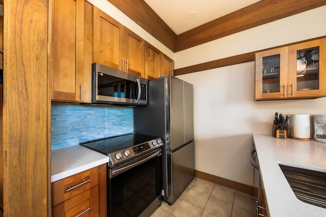 kitchen featuring sink, light stone counters, backsplash, light tile patterned floors, and appliances with stainless steel finishes