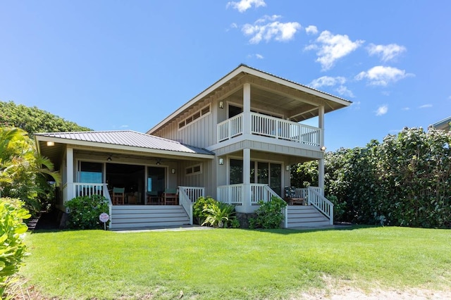 rear view of property featuring a lawn and a balcony