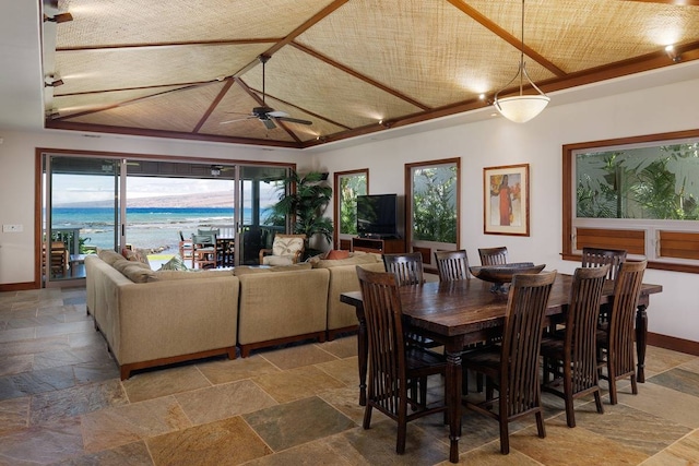 dining space with a water view and ceiling fan