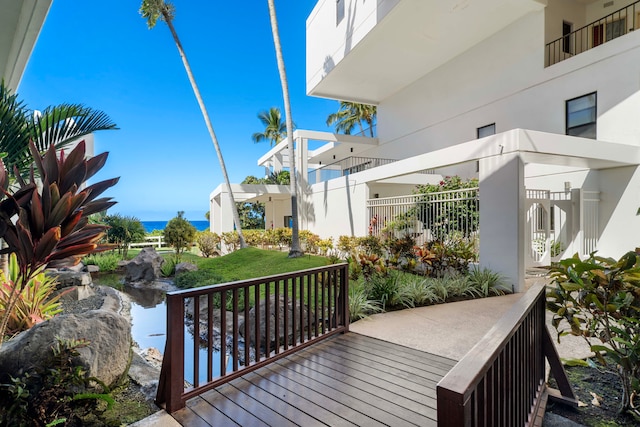 deck featuring a water view and a lawn