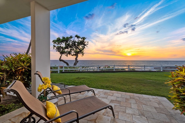 75-6040 Alii Dr Unit 108, Kailua-Kona, HI 96740 - patio terrace at dusk featuring a lawn, a water view, and fence