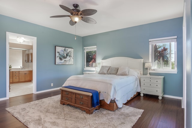 bedroom with ceiling fan, sink, dark wood-type flooring, and connected bathroom