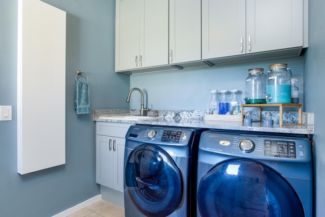 washroom with washer and dryer, light tile patterned floors, cabinets, and sink