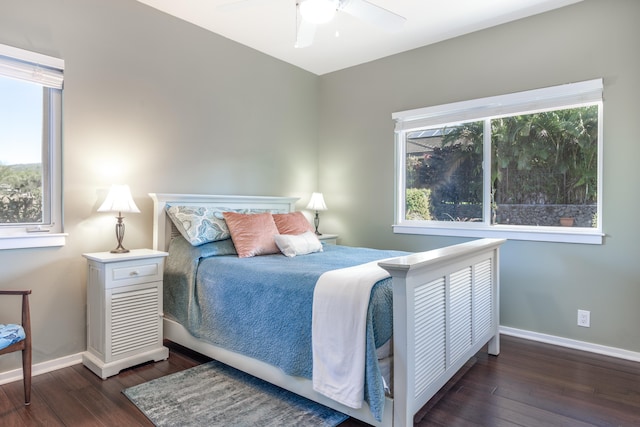 bedroom with ceiling fan, dark hardwood / wood-style floors, and multiple windows