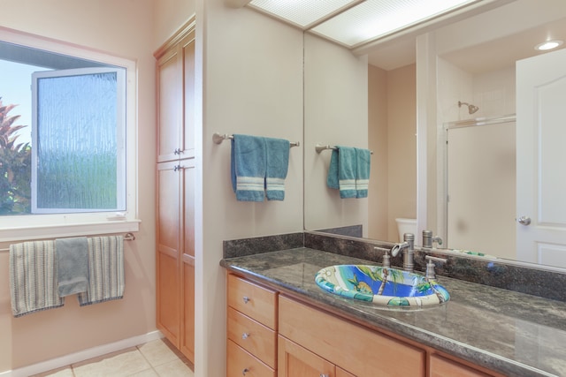 bathroom featuring tile patterned flooring, vanity, toilet, and an enclosed shower