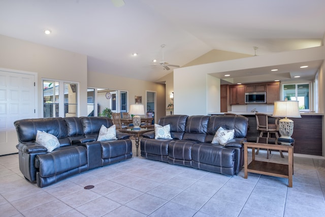 living room featuring light tile patterned floors, vaulted ceiling, and ceiling fan