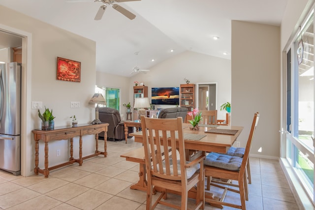 dining room with ceiling fan, a healthy amount of sunlight, light tile patterned flooring, and vaulted ceiling