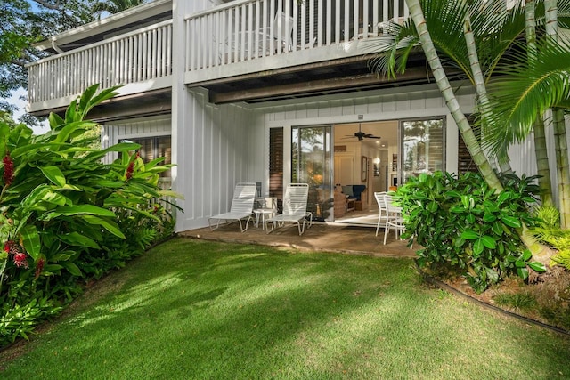 back of house with a lawn, a balcony, and a patio