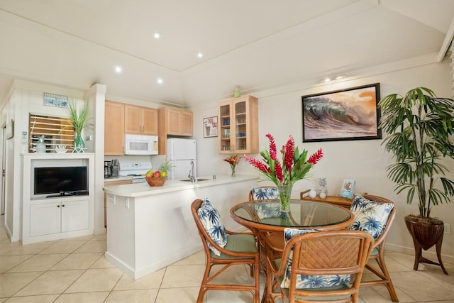 kitchen featuring light brown cabinets, white appliances, sink, light tile patterned floors, and kitchen peninsula