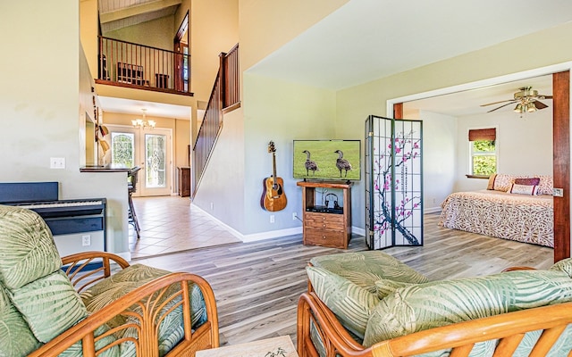 living room with ceiling fan with notable chandelier, plenty of natural light, and hardwood / wood-style flooring