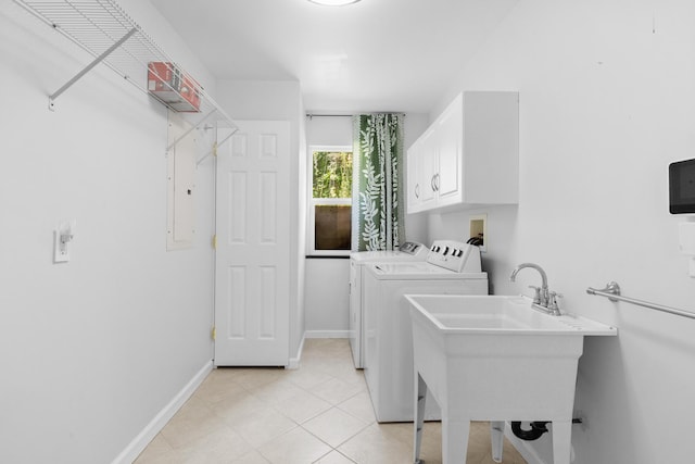 clothes washing area featuring washing machine and dryer, cabinets, and sink