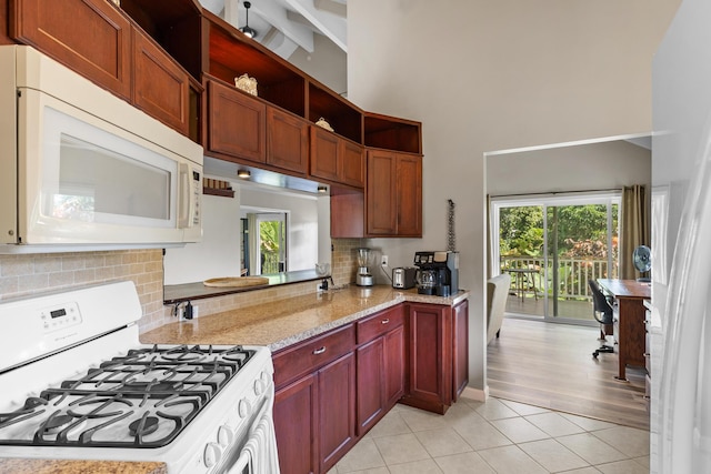 kitchen featuring light stone counters, beamed ceiling, backsplash, light hardwood / wood-style flooring, and white appliances