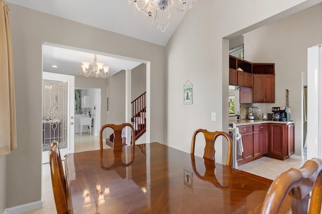 tiled dining space with a chandelier and vaulted ceiling