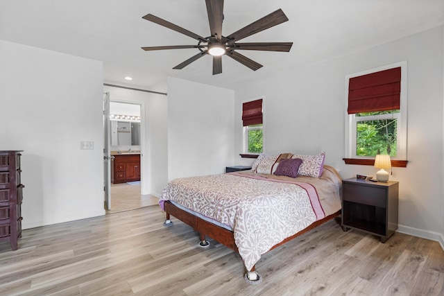 bedroom with ceiling fan, multiple windows, and light wood-type flooring