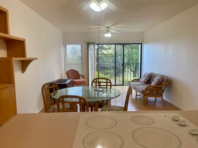 dining area with hardwood / wood-style flooring, ceiling fan, and a textured ceiling