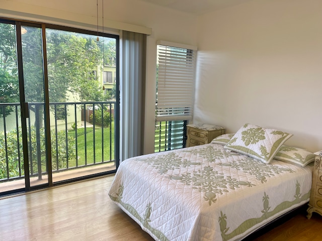 bedroom with hardwood / wood-style flooring and multiple windows