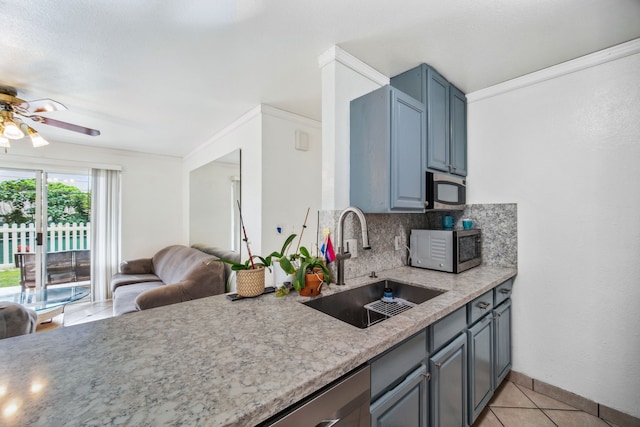 kitchen featuring ceiling fan, sink, light stone counters, decorative backsplash, and light tile patterned floors