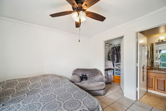 tiled bedroom with ceiling fan, a closet, ensuite bathroom, and ornamental molding