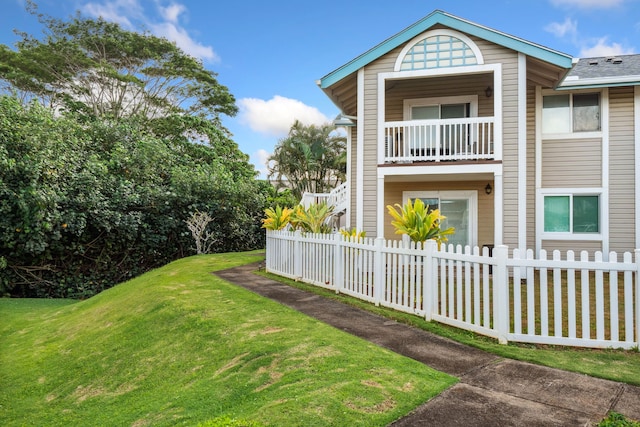 exterior space with a balcony and a lawn