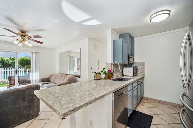 kitchen featuring kitchen peninsula, appliances with stainless steel finishes, tasteful backsplash, sink, and light tile patterned floors