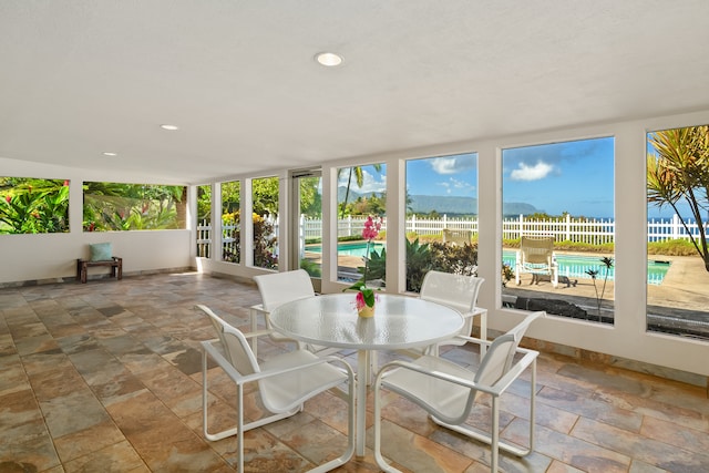 sunroom / solarium featuring a water view