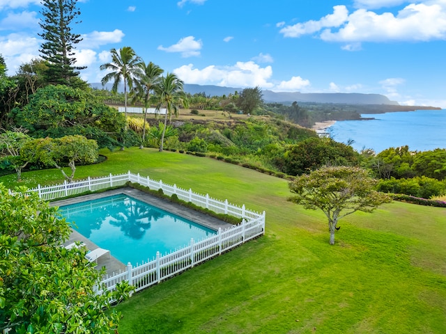 view of swimming pool featuring a lawn and a water view