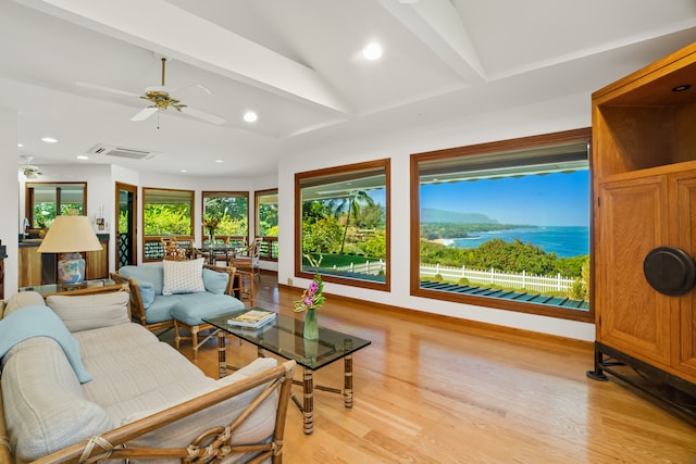 living room featuring light hardwood / wood-style floors, vaulted ceiling with beams, and ceiling fan