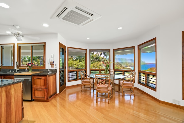 dining area featuring light wood-type flooring, sink, and ceiling fan