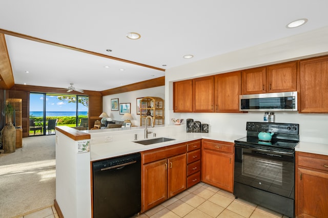 kitchen with sink, black appliances, kitchen peninsula, ceiling fan, and light colored carpet