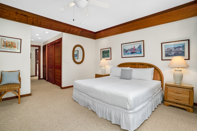 bedroom featuring a closet, light colored carpet, and ceiling fan