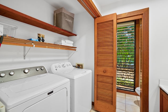 laundry area featuring washing machine and clothes dryer and light tile patterned flooring