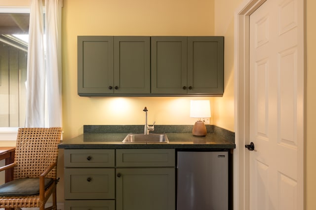 kitchen with sink, stainless steel refrigerator, and green cabinets