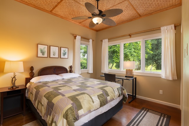 bedroom featuring dark hardwood / wood-style flooring, ceiling fan, and crown molding