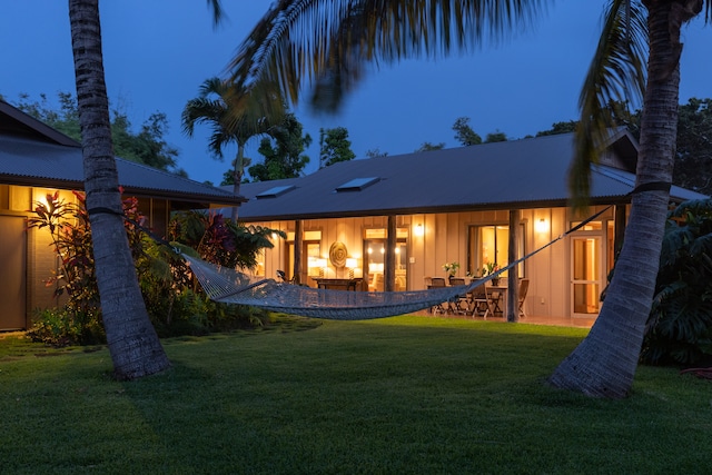 rear view of house featuring a lawn