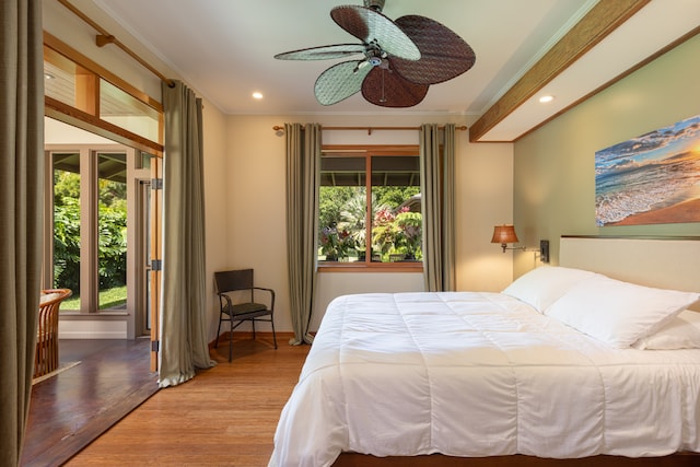 bedroom with hardwood / wood-style flooring, ceiling fan, and crown molding